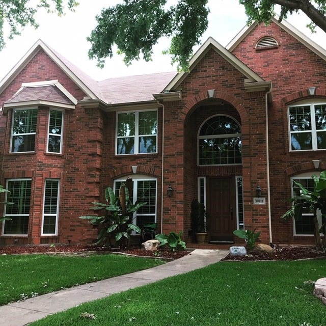 Beautiful brick house exterior with modern framed windows representing Dallas, TX replacement windows