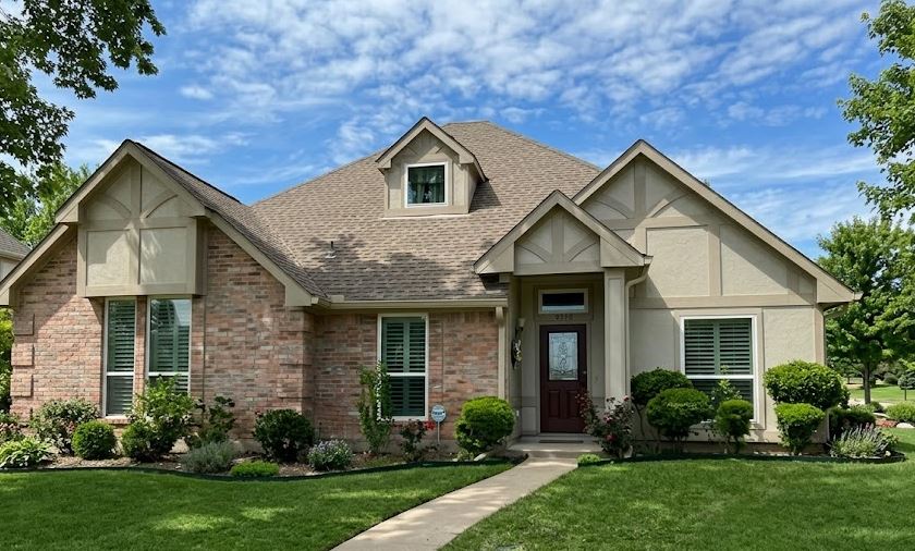 Front view of a beautifully completed window replacement for a brick home in Plano, TX.