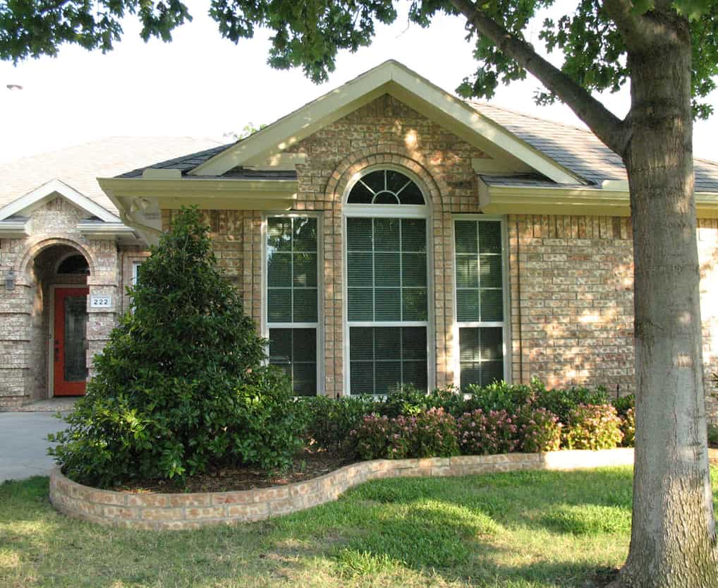 Well-maintained brick residence with stylish front windows promoting Plano, TX replacement windows