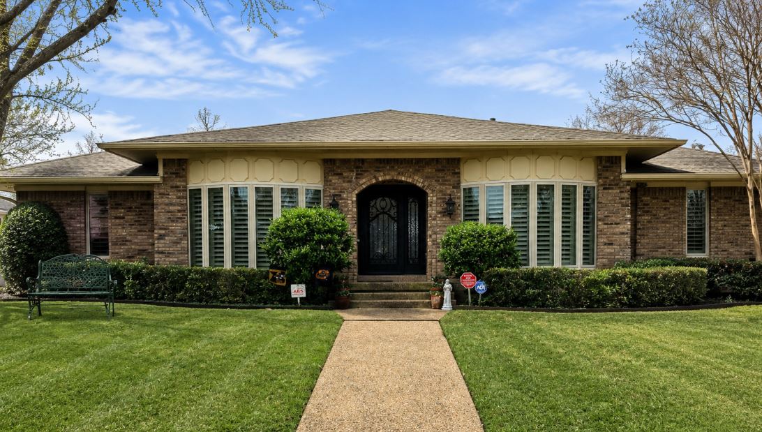 Large replacement windows improve efficiency and natural light across a brick home in Plano, TX